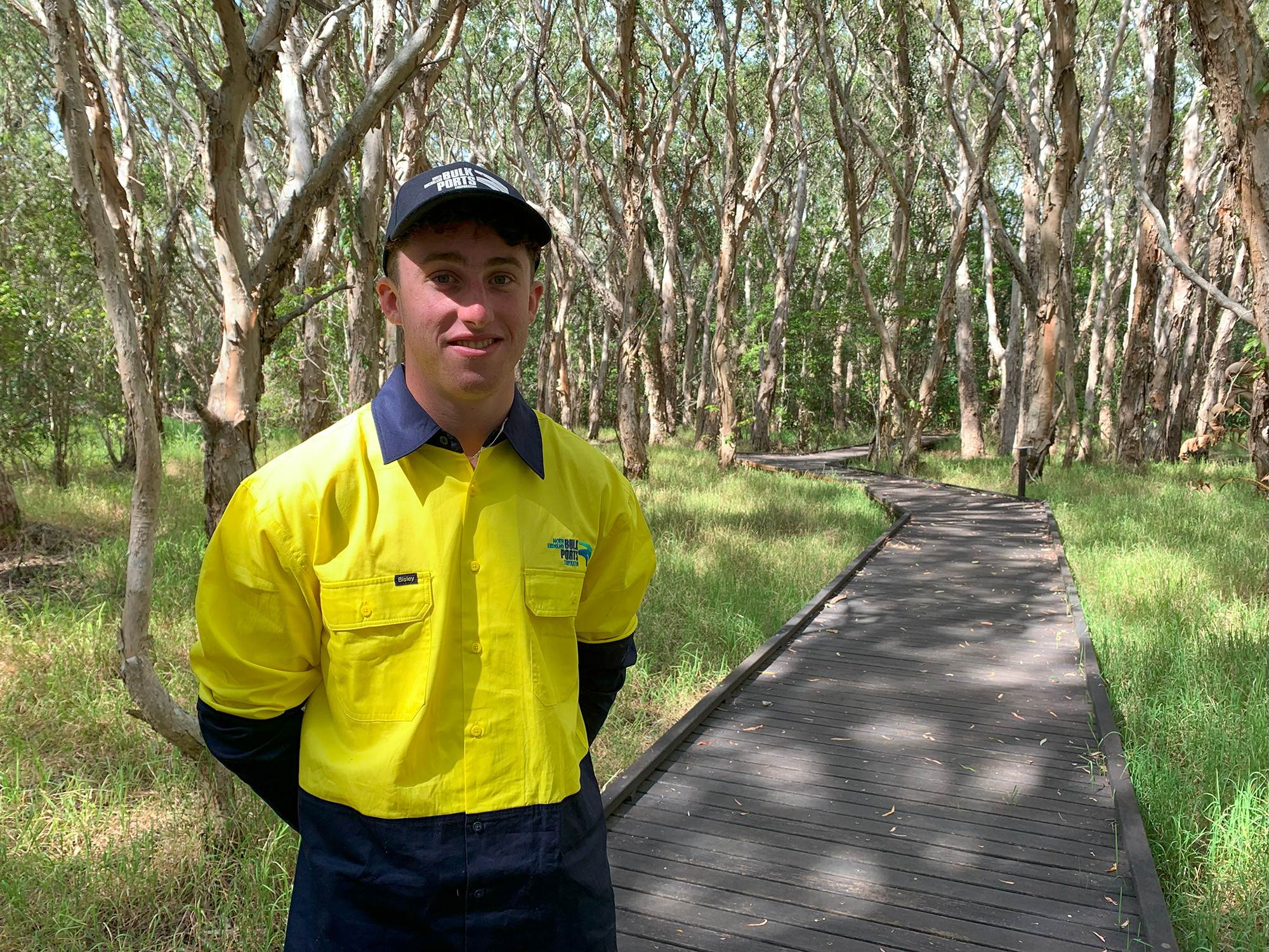 Young male standing in a wetland conservation area in high vis.