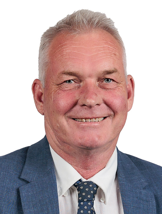 Man crouching in a field with crop