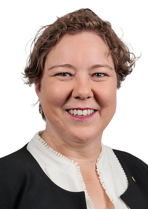 Woman sitting at a table with plants in the background